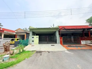 Front facade of terrace house with green carport and red-tiled roof at Taman Rasah Jaya