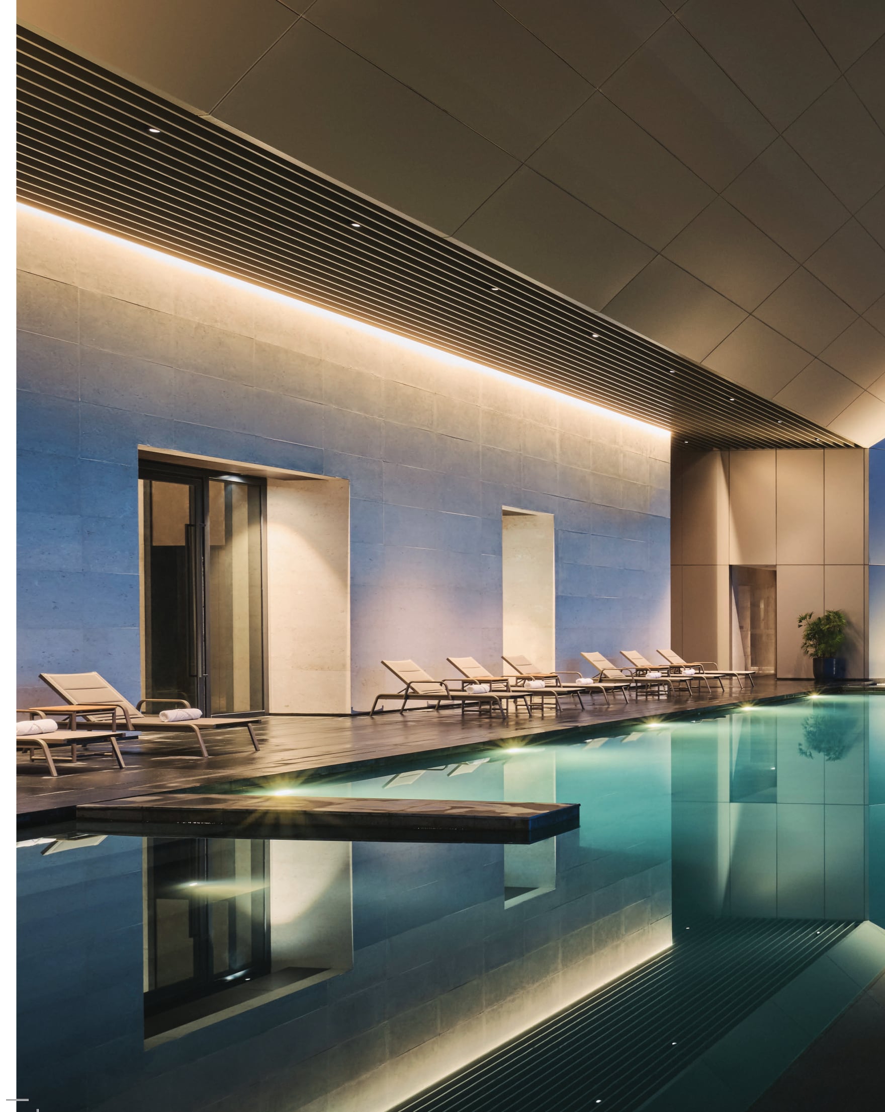 The heated swimming pool — a lap pool under stone and warm light; both facility floors carry one